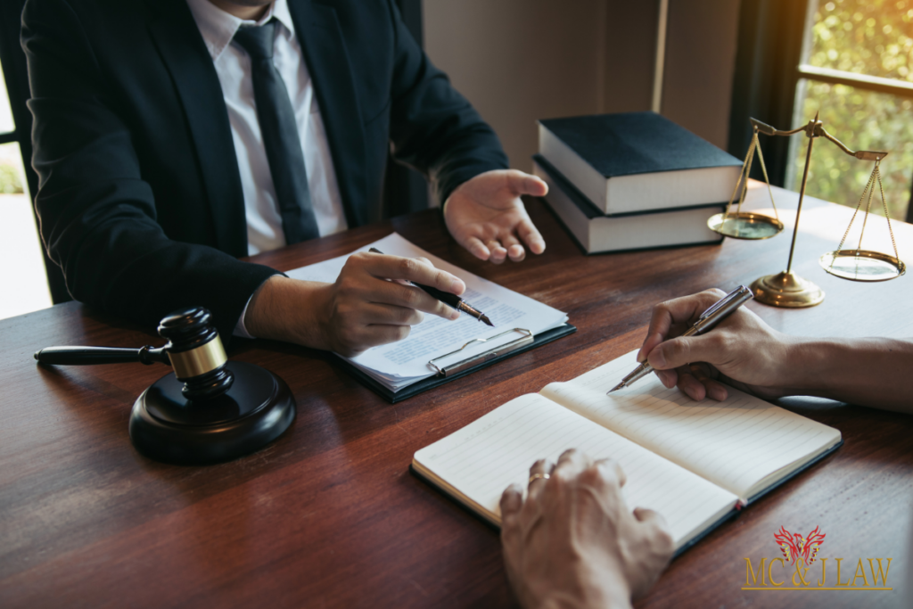  A lawyer and client discussing legal matters at a desk in an office.